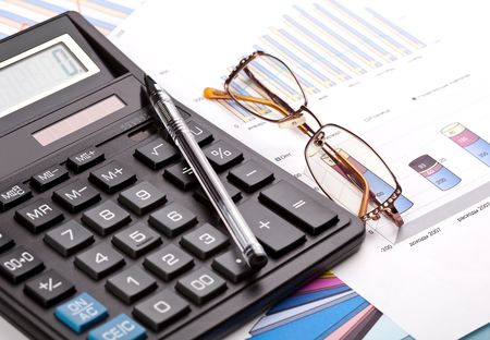  Financial work. The calculator, pen and female eyeglasses on business reportsの写真素材