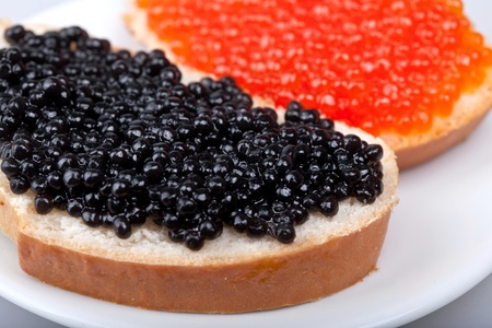 two sandwiches with red and black caviar on plateの写真素材