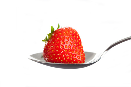 Red strawberry on spoon. Isolated on whiteの写真素材