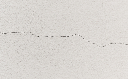 thin horizontal crack in a white concrete wall texture backgroundの写真素材