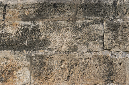 brown old wall on detail of large pieces of stone as bricks rectangular gray backgroundの写真素材