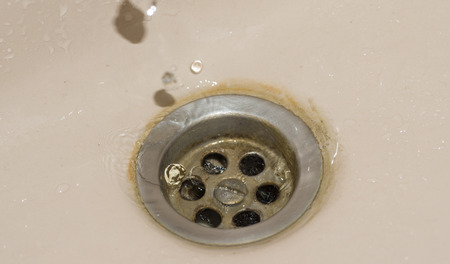 bathroom wash basin drain stack dirty with calcium deposits and whater dropsの写真素材