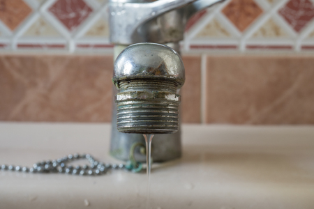 Water tap close-up with limescale soiled calcified faucet water flowingの写真素材
