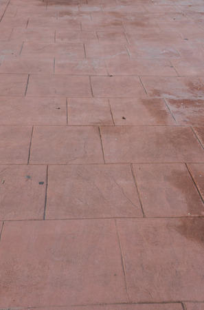 Stamped concrete floor outdoor pavement worn out, perspective, appearance of natural stone, mimics colors and textures of material pavers, red square patternの写真素材