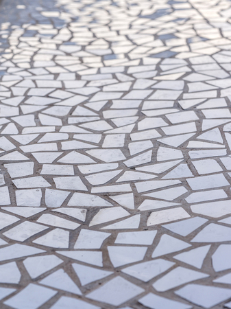 Pattern of broken white tiles, brittle, mosaic, trencadis breakable, enamelled ceramics glazed, perspective view with light reflectionsの写真素材