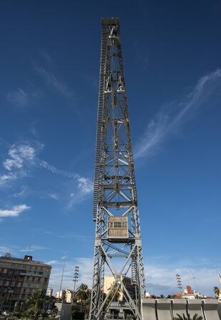 Old port cargo crane, restored out of use. Valencia harbor over blue sky backgroundの写真素材