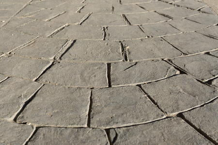 Gray stamped concrete pavement outdoor, mimics cobblestones circular pattern with waves, flooring exterior, decorative appearance colors and textures of paving cobble stone, perspectiveの写真素材