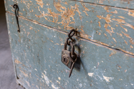 detail of padlock closing an old wooden toolbox, timeworn paintの写真素材