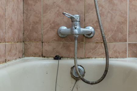 faucet with lime deposit calcified water and tiles with fungi moisture problemの写真素材