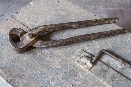 pincers over old tools for housework, vintage look, over old wooden toolbox, timeworn paintの写真素材