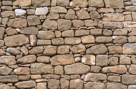 Old stone wall stones fitted together without cement, carved by handの写真素材