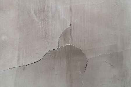 Fissured surfaces thin crack, Deep break in a light yellow concrete cement wall texture backgroundの写真素材