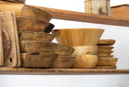 Set of rustic wooden dishes, on a kitchen shelf, isolated on white background. Dish, kitchen bowl