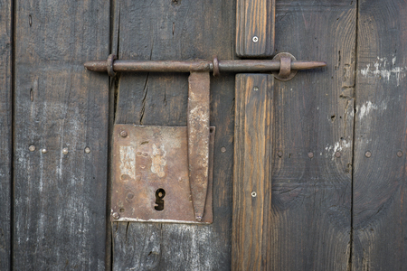 Closeup vintage door lock of external antique wooden door with a door pin lock, weathered on a Country houseの写真素材