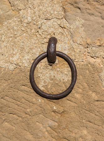 old iron ring a little rusty embedded in a stone wall, used to leave tethered animals like horses or mulesの写真素材