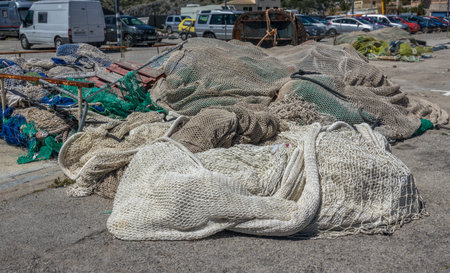 Pile of commercial fishing nets applied to the soil of a port