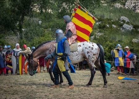 Loarre, Spain - July 09, 2017: Medieval knight riding a horse with swords and shields, reenactment with costumed characters and medieval armor with chainmail, helmet swords and shields. Medieval demonstration and recreationのeditorial素材