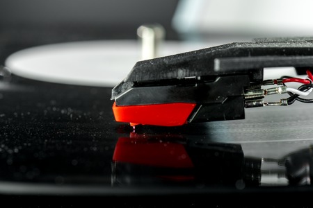 turntable stylus macro detail, needle reading the vinyl. Old record player stylus on a rotating disc, vintage.の写真素材