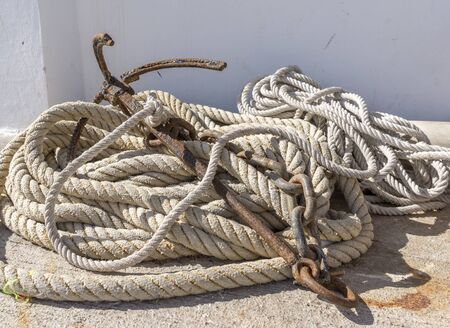 old iron anchor and mooring ropes left on the floorの写真素材