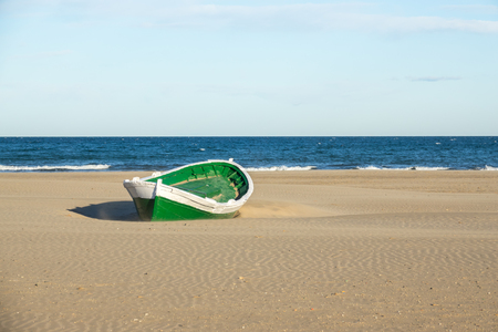 Malvarrosa Valencia Spain, Malvarrosa Valencia Spain wrecked wooden boat. boat stranded in the sand of a beach Broken abandoned boat in sand, sea coast lineの写真素材