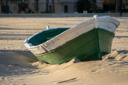 Wrecked wooden fisher boat. boat stranded in the sand of a beach Broken abandoned boat in sandの写真素材