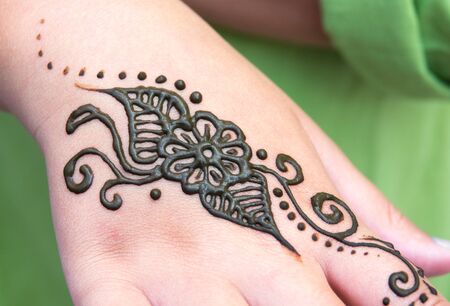 Henna tattoo on a hand, floral motif drawing. henna being applied to hand, freshly applied, still freshの写真素材