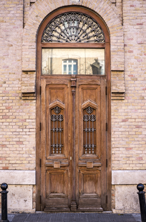 tall wooden door of an old building historic house with exposed brick facade front view. Vertical orientationの写真素材