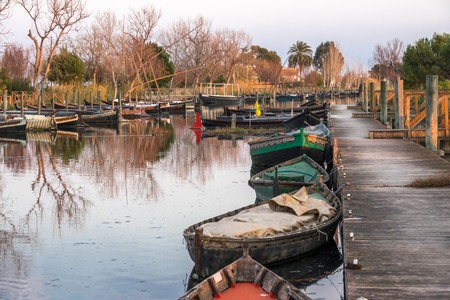 several traditional wooden boats on the mooring dock. harbor of the Albufera nature reserve, Catarroja Valencia Spainの写真素材