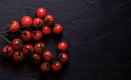 Fresh cherry tomatoes isolated on a black background. Top view with copy spaceの写真素材