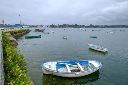 many Small wooden fishing boat drifting Castropol Asturias Spain cloudy day ria de Ribadeo port town on the shore of Cantabrian Seaの写真素材