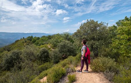 adventure explore woman walking on the path, Sportive woman explore along a meadow roadの写真素材
