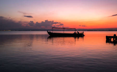 Sunset pier Albufera Valencia tourist ride boat reflections in the lake Natural Park Spain.の写真素材
