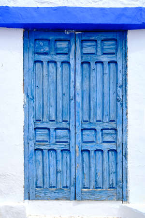 weathered blue wood vintage farmhouse window on white wallの写真素材