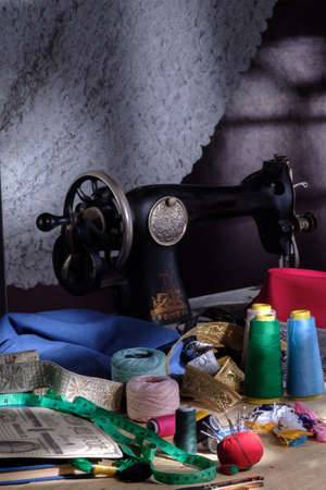 Old tailors workshop with sewing machine, threads, pins and fabrics, traditional vintageの写真素材