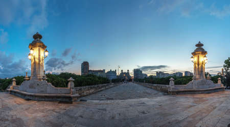 Sea Bridge Valencia Spain, built in 1598, original cobblestone, and antique lamppost, wide angle, sunset, city lights lighting, night viewの写真素材