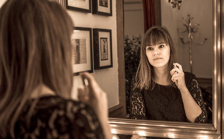 Woman perfume in a vintage bath headdress, aromabeauty elegance and glamor, mirror with decorative lightsの写真素材