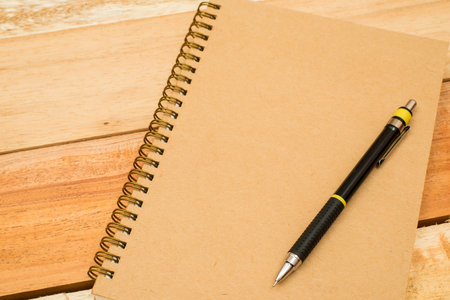 pen and notebook on wooden table. Top viewの写真素材