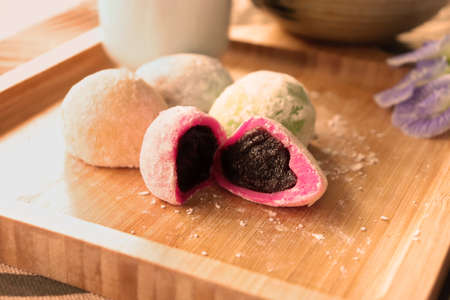 Daifuku Mochi stuffed with sweet red bean paste filling and put on the wooden tray. Vintage style photo.の写真素材