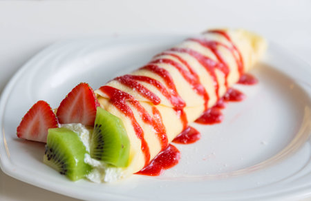 Delicious fruit crepe with a strawberry sauce on top の写真素材