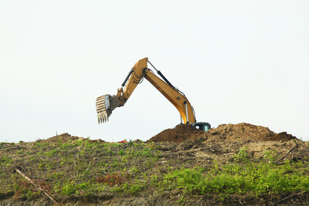The backhoe was digging soil on top mountain.の写真素材