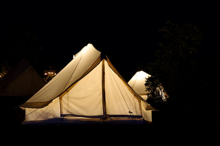 The white tent is camping in the garden at nightの写真素材