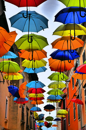 colorful umbrellas hanging on a street in Novigradの写真素材