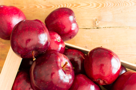 Red Juicy Ripe Apples in a Wooden Crate, the Box is on the Boardsの写真素材