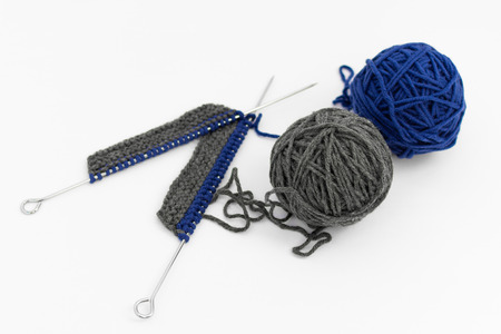 Knitting Needles with Knitting on White Background , Gray and Blue Balls of Woolの写真素材