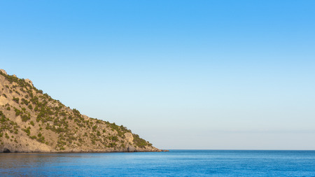 Quiet serene blue sea and wooded mountainside, Vesele bay in the Sudak Municipality of the Crimeaの写真素材