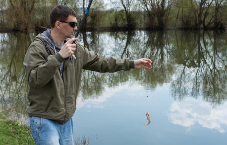 A good catch, fisherman caught a perch on a wormの写真素材