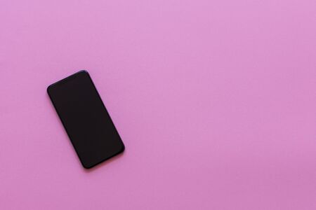 New modern black phone on pink background, flat lay, copy spaceの写真素材