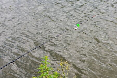 Fishing rod with a bell in the water, fishing in summerの写真素材