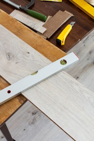 Installation laminate or parquet in the room, worker installing wooden laminate flooring, marking the length of the laminateの写真素材