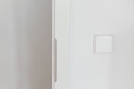 Part of the home or hotel interior, open doorway with white wall and switchの写真素材